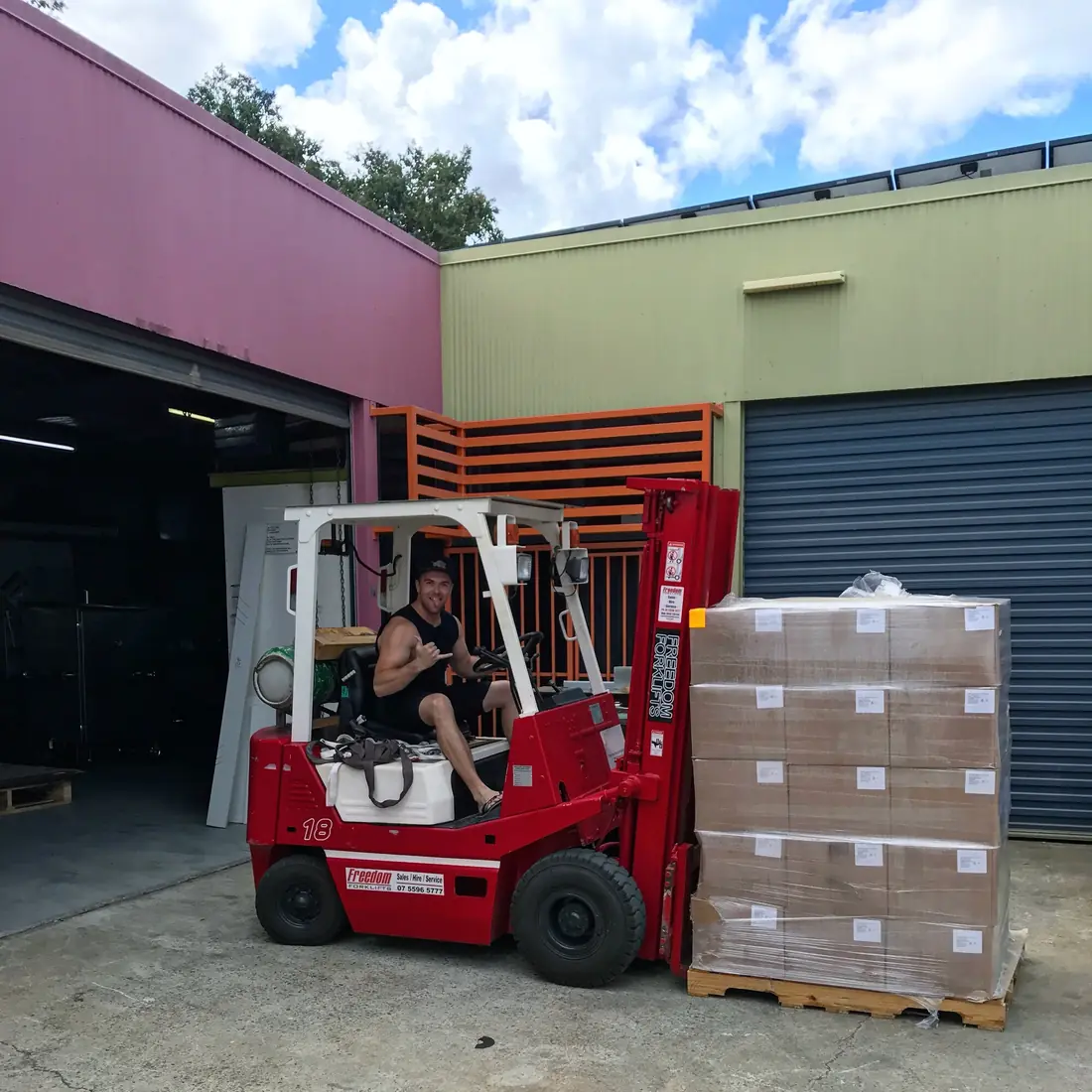 Mike on a forklift next to a wrapped pallet of stock